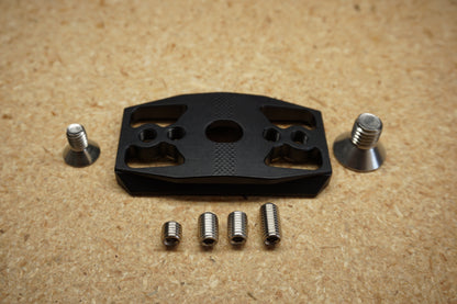 Front view of the Dead Center Arca Plate showing the knurled top surface, center mounting screw, and an adjustment screw on each side
